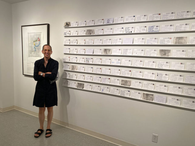 Julie Cowan at Lincoln art show with postcard wall